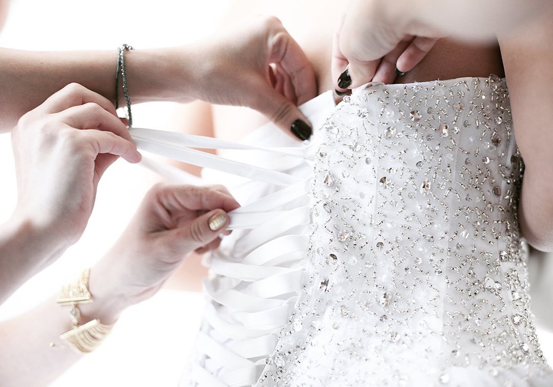 Hands fastening a wedding dress in Paris