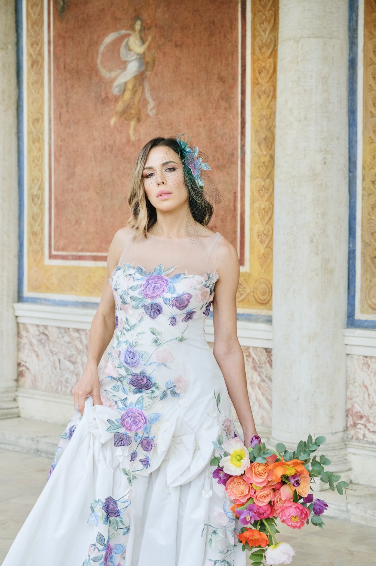 A bride in a floral embroidered dress inside a Roman villa