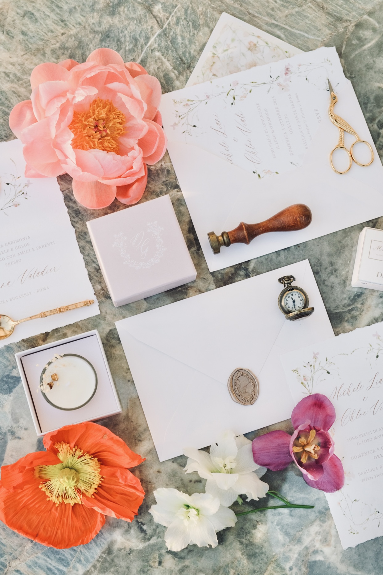Wedding stationery, flowers and small objects arranged on stone