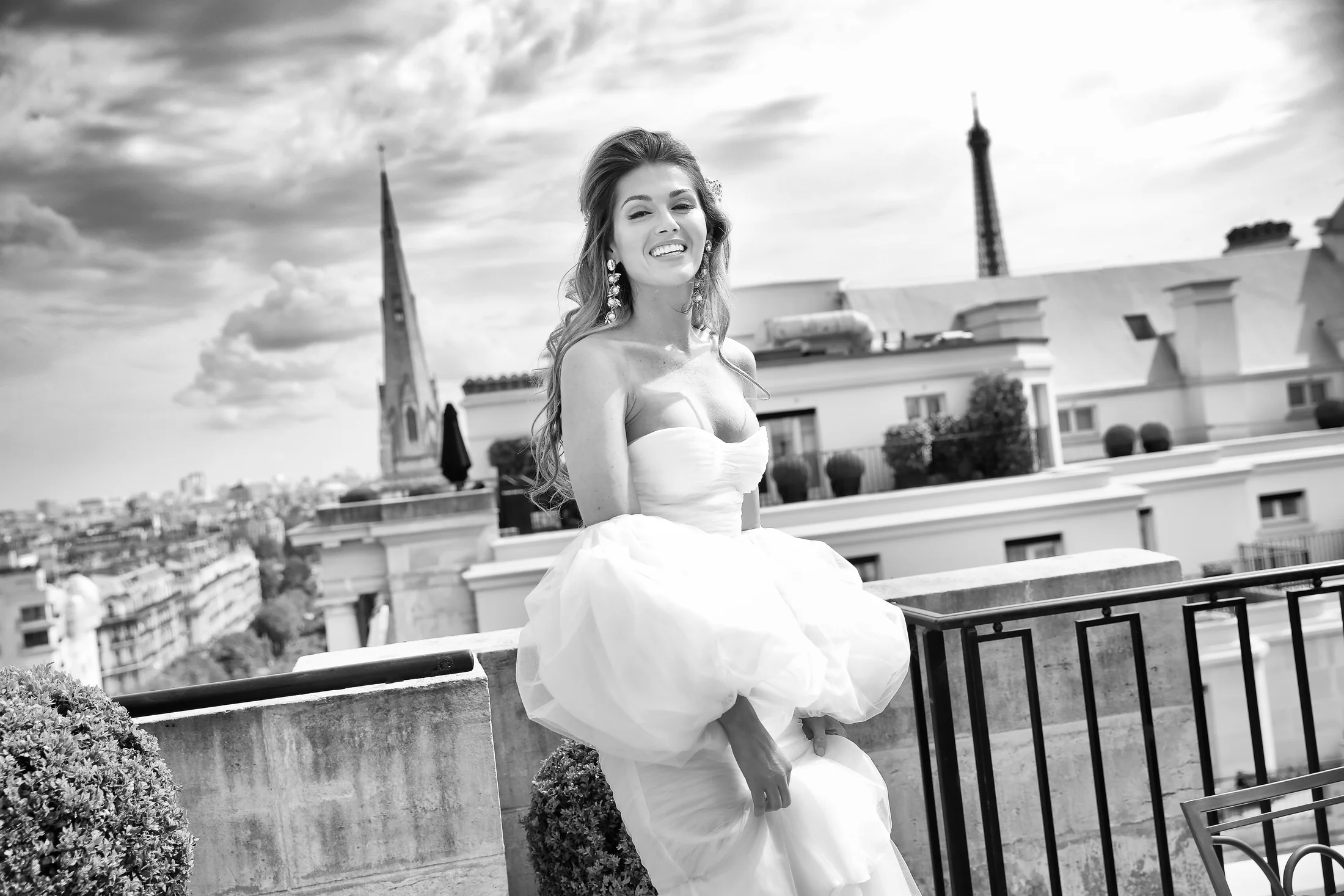 A bride smiling on a Paris terrace in black and white