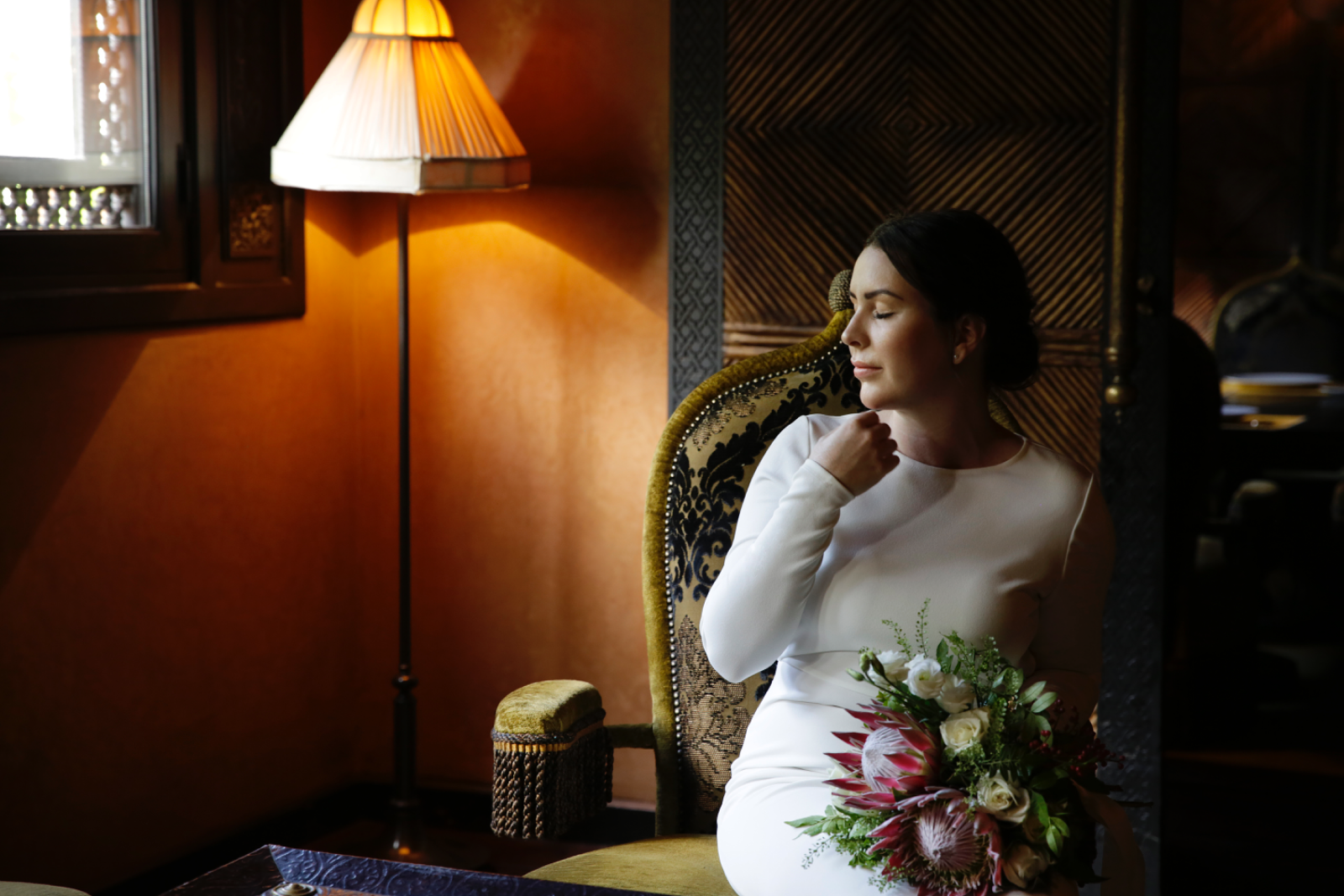 A bride entering an evening celebration beneath chandeliers in Marrakech